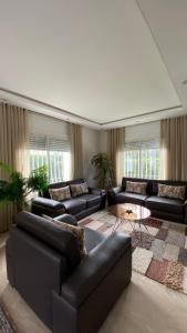 ein großes Wohnzimmer mit Sofas und einem Teppich in der Unterkunft Villa de luxe centrale Harhoura in El Harhoura