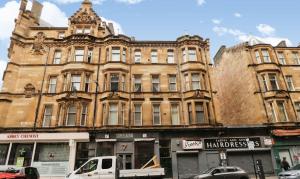 a large building on a street with cars parked in front at Modern Glasgow City Centre Apartment in Glasgow