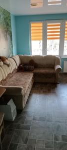 um grande sofá numa sala de estar com paredes azuis em Trumpalaikė nuoma em Elektrėnai