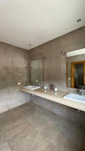 ein Badezimmer mit zwei Waschbecken und einem großen Spiegel in der Unterkunft Villa de luxe centrale Harhoura in El Harhoura
