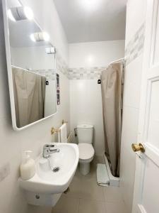 uma casa de banho branca com um WC e um lavatório em Toledo habitaciones em Madri