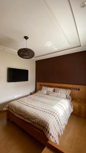 Schlafzimmer mit einem Bett und einem Flachbild-TV in der Unterkunft Villa de luxe centrale Harhoura in El Harhoura