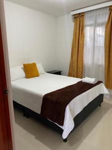a bedroom with a bed and a window at Casa Turistica JM in Armenia