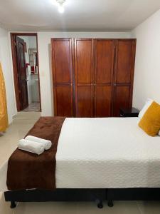 1 dormitorio con 1 cama grande y armario de madera en Casa Turistica HL, en Armenia