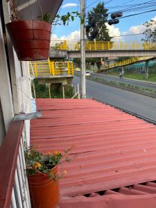 a red wooden walkway with potted plants on a building at Casa Turistica HL in Armenia