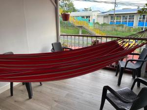 a hammock in a room with chairs and a balcony at Casa Turistica JM in Armenia