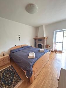 a large bed in a bedroom with a fireplace at CA' EDDA APPARTAMENTO ANNA in Brentonico +1 photo