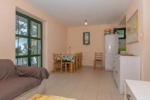 a kitchen and living room with a refrigerator and a table at Holiday home Masha in Bogomolje