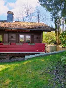 dom z czerwoną ławką na podwórku w obiekcie Bergfreude Chalet w mieście Braunlage
