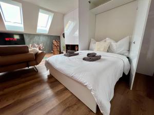 een slaapkamer met een groot wit bed en een bank bij Loftový apartmán Laura in Světlá nad Sázavou