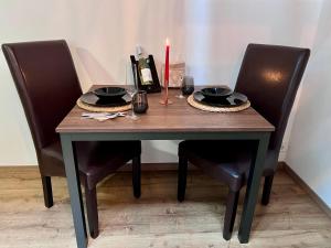 een eettafel met twee stoelen en een kaars erop bij Loftový apartmán Laura in Světlá nad Sázavou