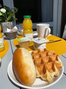 a plate with a sandwich and waffles on a table at Residence Les Villas CROMA in La Roche-Posay +59 photos