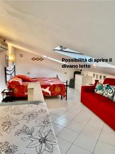 una camera con due letti e un divano rosso di La brezza viareggina a 500 mt dal mare, dal carnevale e dagli stabilimenti balneari a Viareggio