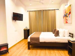 um quarto de hotel com uma cama e uma lareira em Queens Mount Glen Heights em Nuwara Eliya