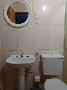 a bathroom with a toilet and a sink and a mirror at RESIDENCIAL LOS AMIGOS in Puerto Iguazú