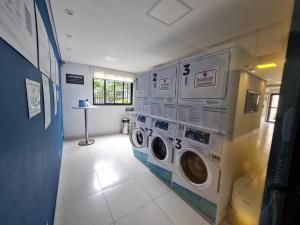 una lavandería con dos lavadoras apiladas en una pared en Studio próximo Avenida Paulista, en São Paulo