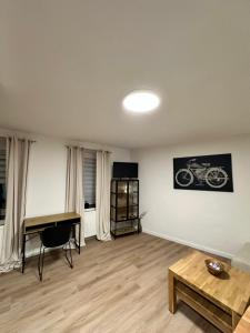 a living room with a desk and a motorcycle on the wall at City Apartment in Sankt Ingbert