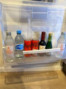 an open refrigerator filled with bottles of soda and drinks at City Apartment in Sankt Ingbert