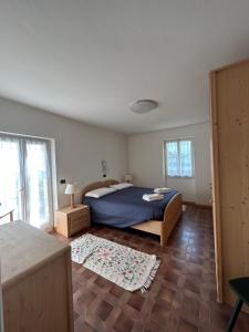 a bedroom with a bed with a blue comforter at CA' EDDA APPARTAMENTO GIULIA in Brentonico