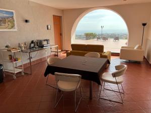 une salle à manger avec une table et des chaises et une fenêtre dans l'établissement Villa Leucatia, à Sant’Agata Li Battiati 