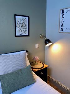 1 dormitorio con 1 cama con lámpara y mesa en Blue Ball Inn, Sandygate, Exeter en Exeter