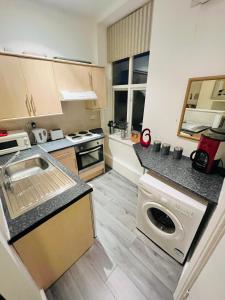 een kleine keuken met een wasmachine en droger. bij Studio flat in Shipley Central in Shipley