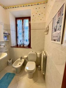 La salle de bains blanche est pourvue de toilettes et d'un lavabo. dans l'établissement La brezza viareggina a 500 mt dal mare, dal carnevale e dagli stabilimenti balneari, à Viareggio