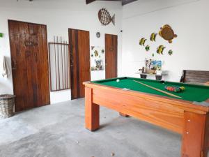 a pool table in a living room with a pool at Pousada Alecrim in Aquiraz