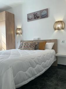 - une chambre avec un grand lit blanc et deux lumières dans l'établissement Relax&enjoy II (Las Tuneras), à Puerto Rico
