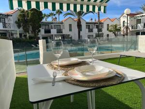 - une table avec des assiettes et des verres à vin sur la terrasse dans l'établissement Relax&enjoy II (Las Tuneras), à Puerto Rico