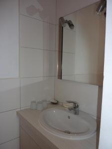 a white bathroom with a sink and a mirror at Chambres d'hôtes : La Isla Bonita in L'Ile-Bouchard