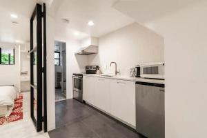 a kitchen with white cabinets and a sink at Central Location Brooklyn Stay at Rem-Casa in Brooklyn