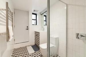 a white bathroom with a toilet and a shower at Central Location Brooklyn Stay at Rem-Casa in Brooklyn