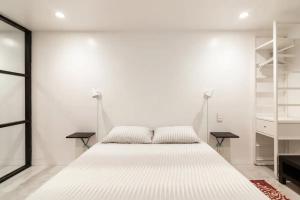 a white bedroom with a large bed and shelves at Central Location Brooklyn Stay at Rem-Casa in Brooklyn