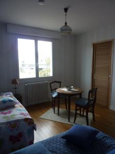 um quarto com uma mesa e cadeiras e uma janela em Chambres d'hôtes : La Isla Bonita em L'Ile-Bouchard