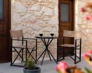 two chairs and a table with two cups on it at EliteDIMension Chalki in Halki