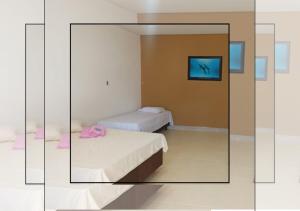 Pokój z 2 łóżkami i lustrem w obiekcie Pousada Praia Sol do Indaiá w mieście Bertioga