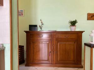 une armoire en bois avec deux plantes en pot au-dessus dans l'établissement Le Siepi, à Reggello