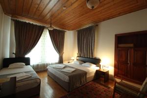 a bedroom with two beds and a large window at Konya Dervish Hotel in Konya