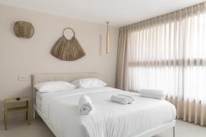 een slaapkamer met een wit bed en handdoeken bij Diamond in the Desert- for families in Eilat