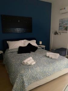 Un dormitorio azul con una cama con toallas. en Casa Galatea, en Aci Trezza