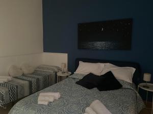- une chambre avec un lit et des serviettes dans l'établissement Casa Galatea, à Aci Trezza