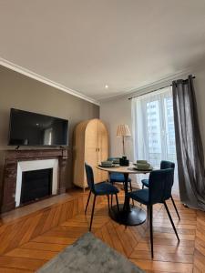 Una sala de estar con mesa y sillas y una chimenea. en Le Charmant - Parking Gratuit, Wifi, RER C Choisy-le-Roi, en Choisy-le-Roi