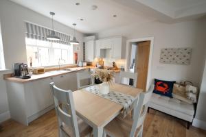 a kitchen with a wooden table and a dining room at Church St. Retreat, Filey in Filey