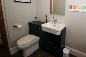 a bathroom with a white toilet and a sink at Church St. Retreat, Filey in Filey