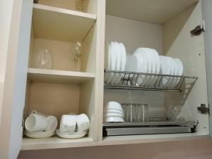 a cupboard filled with white plates and dishes at House number 1 in kutaisi in Kutaisi