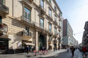 una calle en una ciudad con gente caminando en Napolit'amo Hotel Principe, en Nápoles