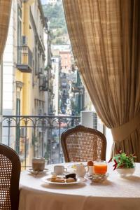 uma mesa com um prato de comida em cima de uma janela em Napolit'amo Hotel Principe em Nápoles