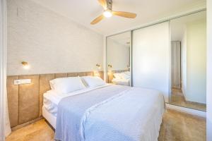 a bedroom with a white bed and a large mirror at Bello Horizonte in Altea +21 photos