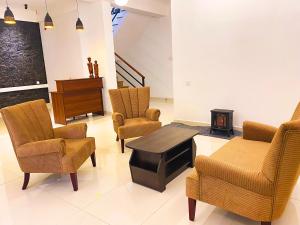 a living room with chairs and a table and a piano at Queens Mount Glen Heights in Nuwara Eliya